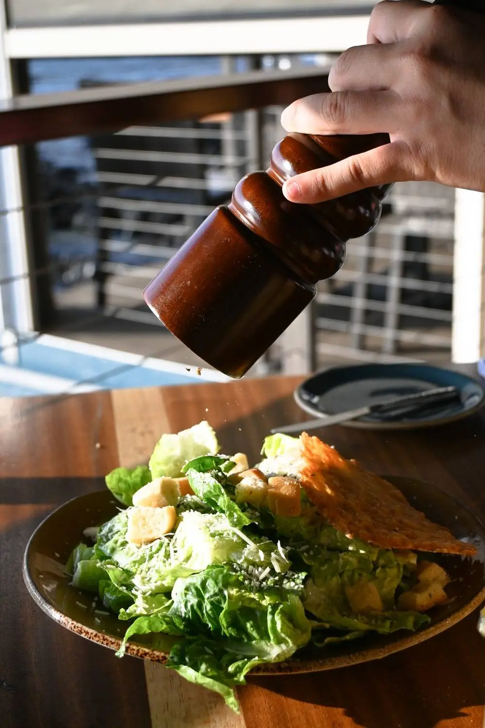 Fresh-cracked pepper over a Caesar salad
