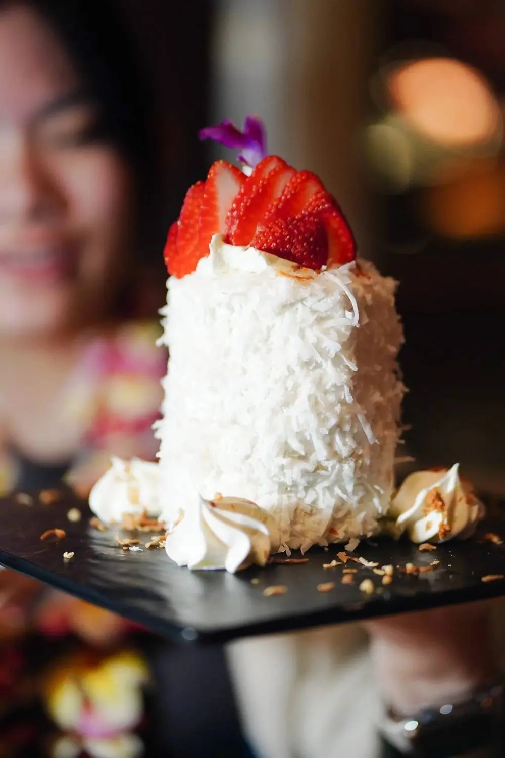 A guest with the coconut cake at the table