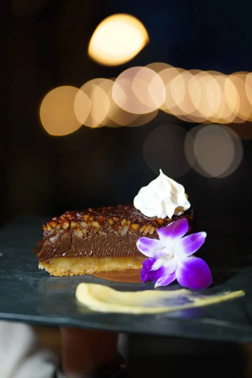 Plated chocolate dessert under the bar lights