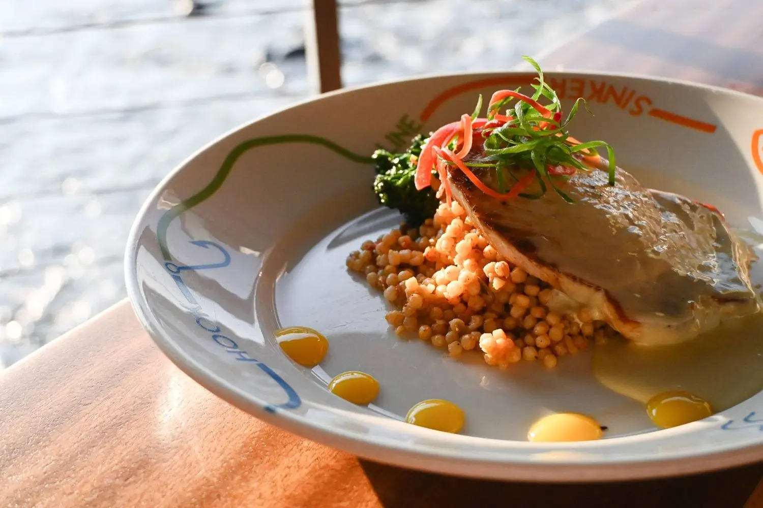 Fresh island fish plated with citrus and couscous