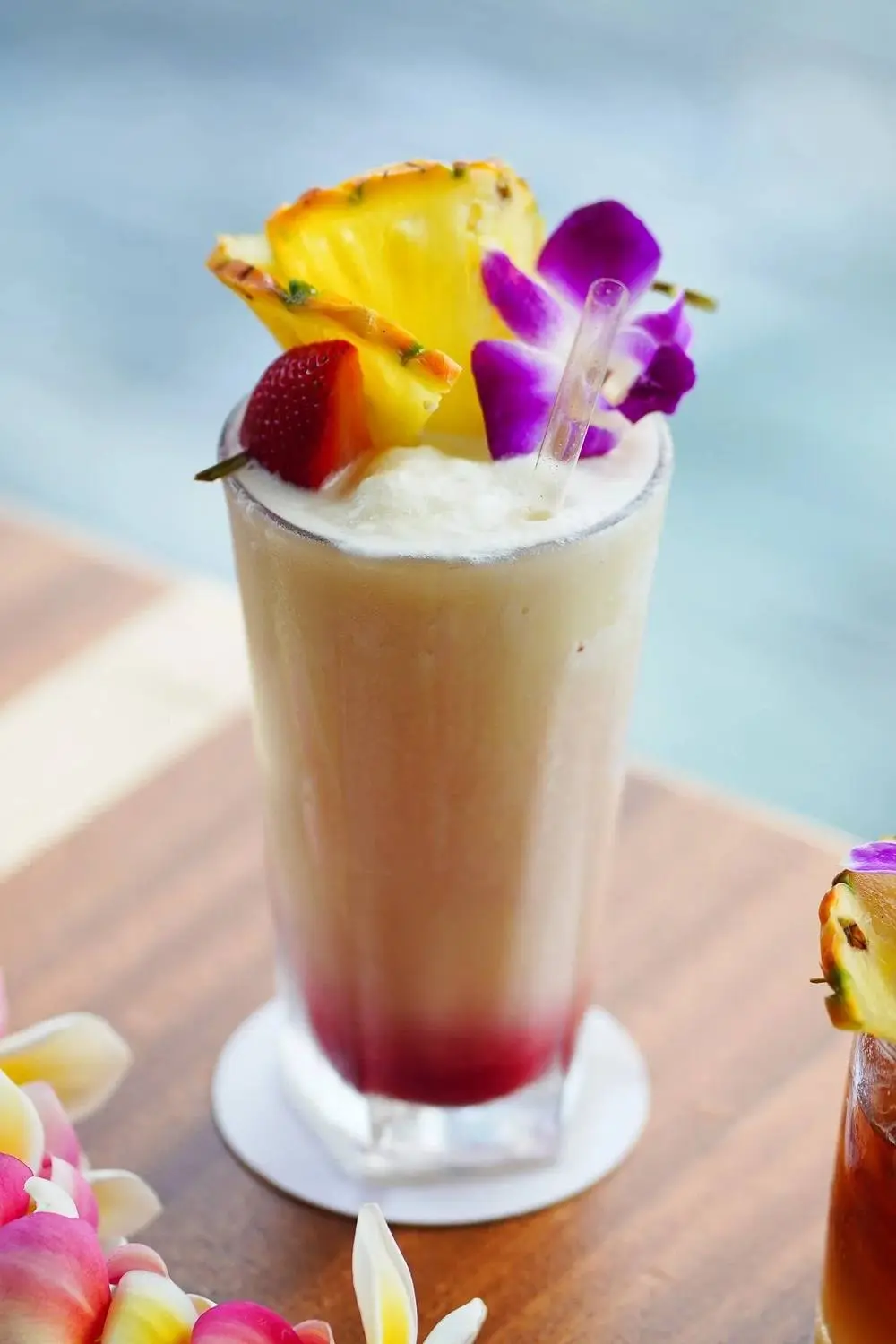 A Lava Flow cocktail garnished with pineapple and orchid