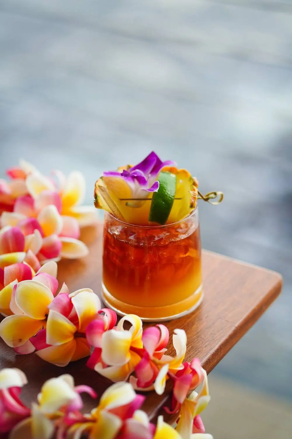 A classic Mai Tai beside a plumeria lei