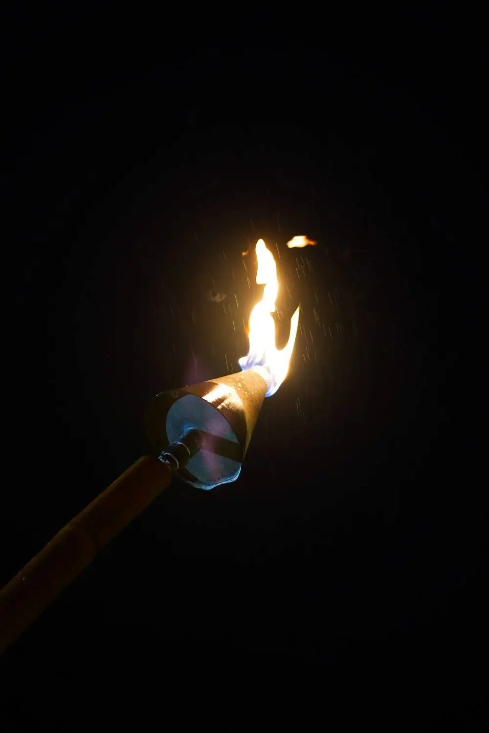 A tiki torch burning after dark